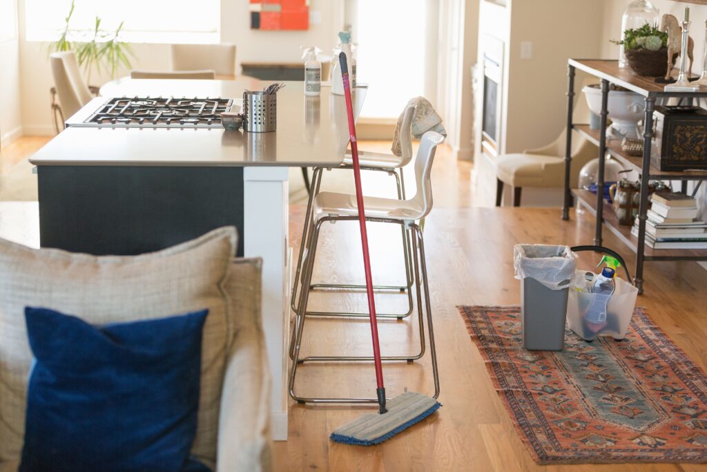 Residential cleaning doneby best cleaning service company in Qatar. A mop stading against kitchen counter.